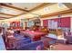 Bright recreation room with pool tables, seating, and signs for 
