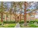 Exterior view of a two-story condo building with mature trees and a well-manicured lawn at 2050 W Warm Springs Rd # 312, Henderson, NV 89014