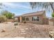 The backyard has desert landscaping with mature trees, a covered patio, and a built-in BBQ area at 2056 Bay Thrush Way, North Las Vegas, NV 89084