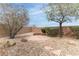 Backyard with rock landscaping, custom stone sitting area, and privacy wall at 2056 Bay Thrush Way, North Las Vegas, NV 89084