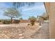 This backyard has rock landscaping, mature trees, and covered patio with a grill at 2056 Bay Thrush Way, North Las Vegas, NV 89084