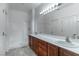 Bathroom with dual sinks, modern vanity, tiled floors, and glass-enclosed shower at 2056 Bay Thrush Way, North Las Vegas, NV 89084