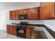 Well-lit kitchen featuring wood cabinets, granite countertops, and modern, black appliances at 2056 Bay Thrush Way, North Las Vegas, NV 89084