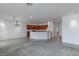 Open-concept living space with kitchen, neutral paint, plush carpeting, and modern lighting at 2056 Bay Thrush Way, North Las Vegas, NV 89084