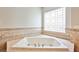 Close up of a bathtub featuring tile surround and glass block window at 213 Villa Borghese St, Las Vegas, NV 89138