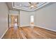 Open bedroom with hardwood floors, neutral walls, tray ceiling, and views to the bathroom at 213 Villa Borghese St, Las Vegas, NV 89138