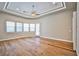 Bright bedroom with hardwood floors, ceiling fan, tray ceiling, and natural light from large windows at 213 Villa Borghese St, Las Vegas, NV 89138