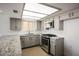 Bright kitchen featuring stainless steel appliances, wood floor, gray cabinets, and granite countertops at 2316 Pine Bluff Ct, Las Vegas, NV 89134