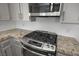 Updated kitchen featuring stainless steel appliances, granite countertops, and gray cabinets at 2316 Pine Bluff Ct, Las Vegas, NV 89134