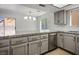 Bright kitchen featuring stainless steel appliances, wood floor, gray cabinets, and granite countertops at 2316 Pine Bluff Ct, Las Vegas, NV 89134