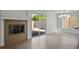 Bright living room with tile floors, fireplace, sliding glass door, and modern light fixture at 2316 Pine Bluff Ct, Las Vegas, NV 89134