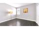 A bedroom with wood floors, a decorative lamp and art, and white walls at 2395 Arrington Ave, North Las Vegas, NV 89086