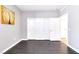 An airy bedroom with dark wood floors and a white sliding door closet at 2395 Arrington Ave, North Las Vegas, NV 89086