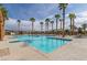 Resort-style community pool with palm trees and lounge areas under a sunny sky at 2395 Arrington Ave, North Las Vegas, NV 89086