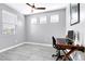 A home office featuring three windows, tile floors and a traditional-style desk at 2395 Arrington Ave, North Las Vegas, NV 89086