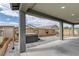 Large, covered patio with hot tub, hardscape, outdoor lighting, and stucco pillars at 2395 Arrington Ave, North Las Vegas, NV 89086