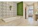 Elegant bathroom featuring a soaking tub with tile surround and decorative wallpaper and greenery at 2497 Birch Hollow St, Henderson, NV 89044