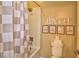Full bathroom featuring a shower over bath setup, neutral patterned curtain and 'Bath' decor at 2497 Birch Hollow St, Henderson, NV 89044