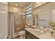 Well-lit bathroom with tiled walk-in shower, modern vanity, and a large mirror at 2497 Birch Hollow St, Henderson, NV 89044