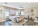 Bedroom with a king-size bed, neutral tones, large windows, and a ceiling fan at 2497 Birch Hollow St, Henderson, NV 89044