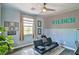Charming bedroom featuring a futon, a decorative wall, and a ceiling fan at 2497 Birch Hollow St, Henderson, NV 89044