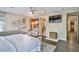 Bedroom with king bed, tv, decorative brick wall, leading to bathroom featuring hardwood floors at 2497 Birch Hollow St, Henderson, NV 89044
