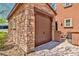 A stone detached garage with a wood garage door at 2497 Birch Hollow St, Henderson, NV 89044