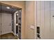 Hallway with dark-stained wood floors and wallpaper leading to a bathroom at 2497 Birch Hollow St, Henderson, NV 89044