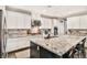 Kitchen with stainless appliances, white cabinets, large granite island, and eat-in counter seating at 2497 Birch Hollow St, Henderson, NV 89044