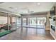 Bright living room with dark hardwood floors, a ceiling fan, and glass doors leading to the patio at 2497 Birch Hollow St, Henderson, NV 89044