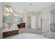 Bathroom featuring dual sinks, dark wood cabinetry, a corner tub, and a glass-enclosed shower at 2753 Kildrummie St, Henderson, NV 89044