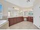 Bathroom with a tub, dual sinks, dark wood cabinets, and large mirrors at 2753 Kildrummie St, Henderson, NV 89044