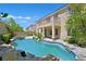 Lush backyard featuring a sparkling pool, a stone waterfall, a spa, and desert landscaping at 2753 Kildrummie St, Henderson, NV 89044