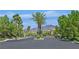Gated community entrance with lush landscaping, mature trees, and mountain views beyond at 2753 Kildrummie St, Henderson, NV 89044