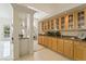 Gourmet kitchen features custom wood cabinets with glass inserts, granite counters, and backyard views at 277 Dark Forest Ave, Las Vegas, NV 89123