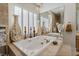 Elegant soaking tub with tile surround, plantation shutters, and gold hardware at 277 Dark Forest Ave, Las Vegas, NV 89123