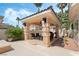 Outdoor patio area features a pergola with seating, mature landscaping, and accent lighting at 277 Dark Forest Ave, Las Vegas, NV 89123