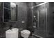 Sleek bathroom with dark tiles, a floating vanity, a modern toilet, and a glass-enclosed shower at 3111 Bel Air Dr # 27E, Las Vegas, NV 89109
