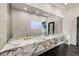 Modern bathroom featuring double sinks with designer faucets, marble countertop, and contemporary mirror at 3111 Bel Air Dr # 27E, Las Vegas, NV 89109