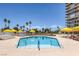 Relaxing pool area with lounge chairs, umbrellas, palm trees and a view of the high rise in the background at 3111 Bel Air Dr # 27E, Las Vegas, NV 89109