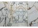 Close-up of a glass enclosed shower with beautiful marble design at 3111 Bel Air Dr # 27E, Las Vegas, NV 89109