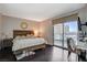 Cozy bedroom featuring a wooden bed frame, dark wood floors, and a sliding door to a balcony with city views at 322 Karen Ave # 601, Las Vegas, NV 89109