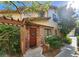Charming townhouse entrance with a brick accent wall and a decorative wooden door at 3232 Dayflower St # 4, Las Vegas, NV 89121