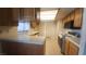 Well-lit kitchen with tile countertops, wood cabinets, and a cozy breakfast nook at 3232 Dayflower St # 4, Las Vegas, NV 89121