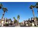 Beautiful street view of townhomes with palm trees and a secure gated entrance under a bright sky at 3232 Dayflower St # 4, Las Vegas, NV 89121