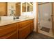 Bathroom featuring wood vanity, double mirrors, and a separate area for the toilet and shower at 3236 Manzanita Ln, Laughlin, NV 89029