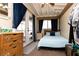 Bedroom featuring a comfortable bed, rustic dresser, and access to outdoor light and fresh air at 3236 Manzanita Ln, Laughlin, NV 89029