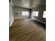 Bright living room featuring wood-look flooring, multiple windows for natural light, and a neutral color palette at 3710 Royal Fern Cir, Las Vegas, NV 89115