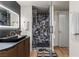 Bathroom features a modern vanity, lighted mirror and glass enclosed shower with stone tile at 3726 Las Vegas Blvd # 606, Las Vegas, NV 89158
