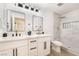 Modern bathroom featuring dual sinks, white cabinets, and a stylish marble-tiled shower with a decorative niche at 4237 E Twain Ave, Las Vegas, NV 89121